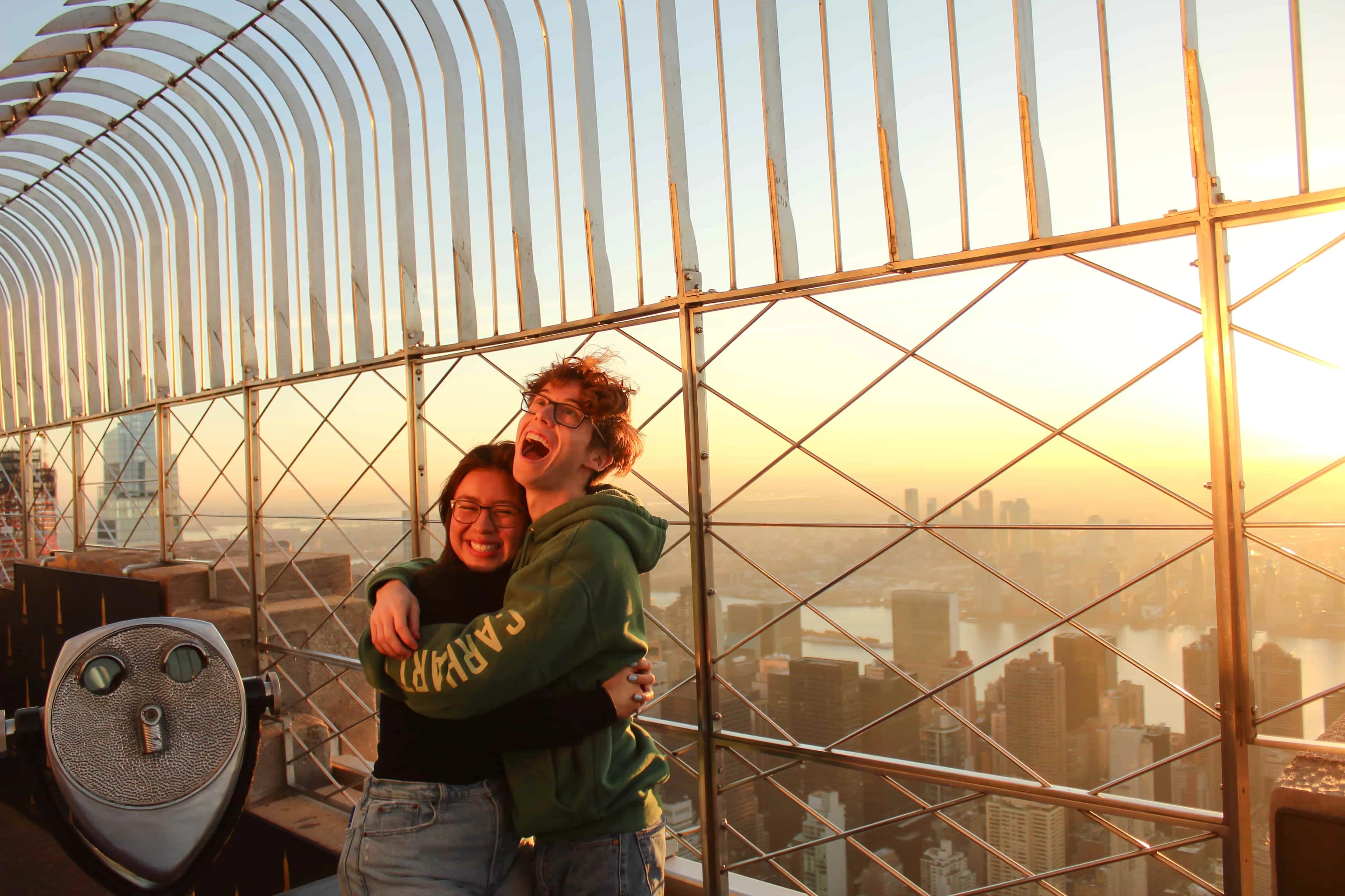 Two friends enjoying the view of NYC sunrises at the Empire State Building