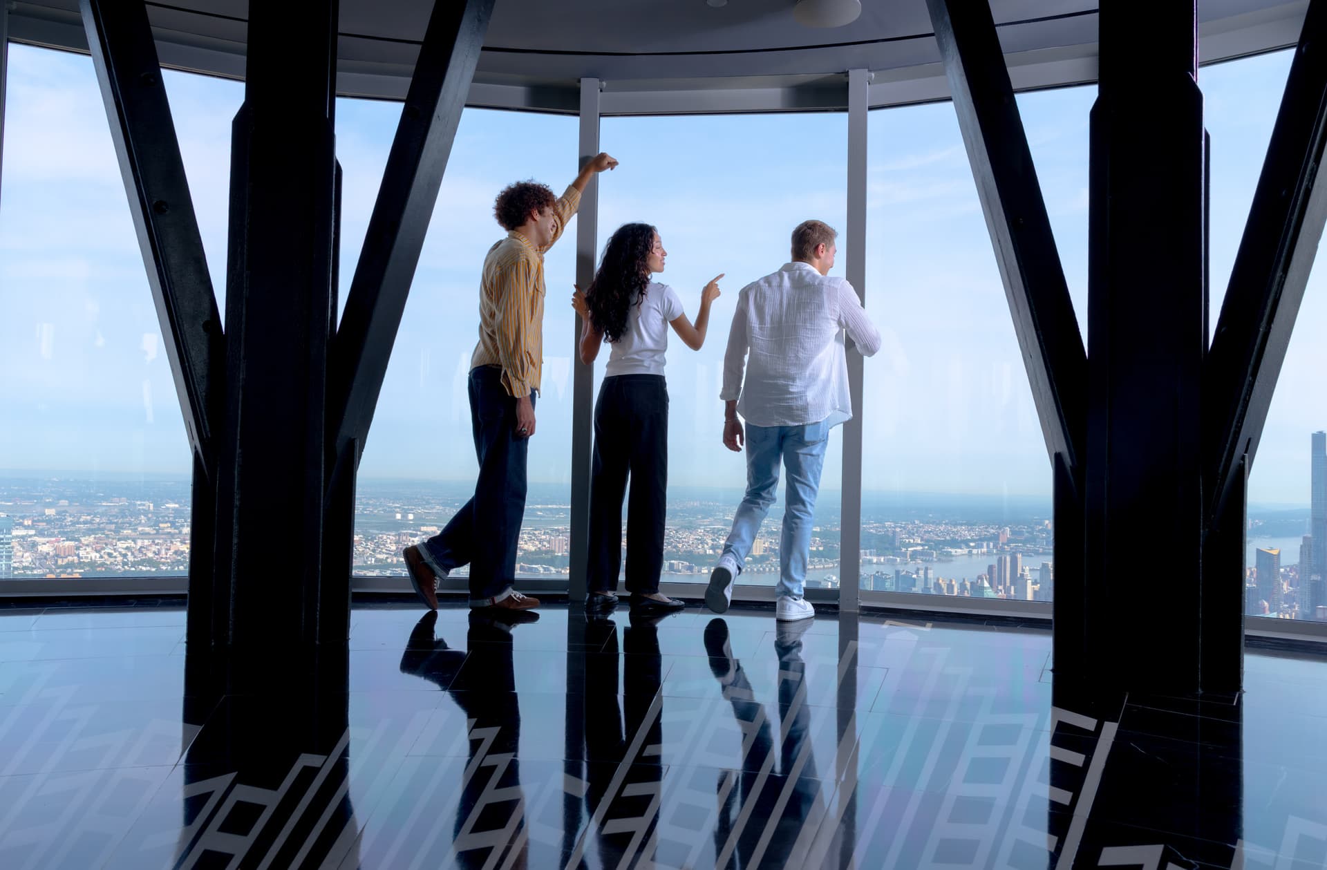 Group of friends looking out to the NYC skyline on the 102nd Floor Observatory of the Empire State Building