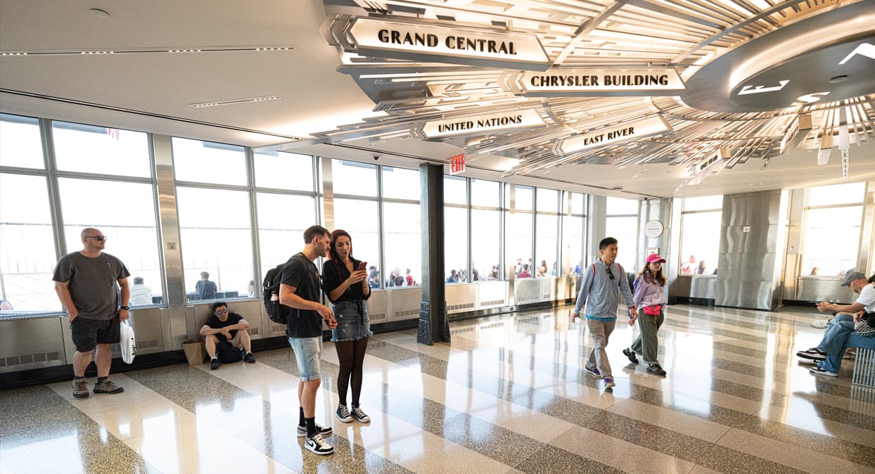 People walking around the 86th floor of the Empire State Building