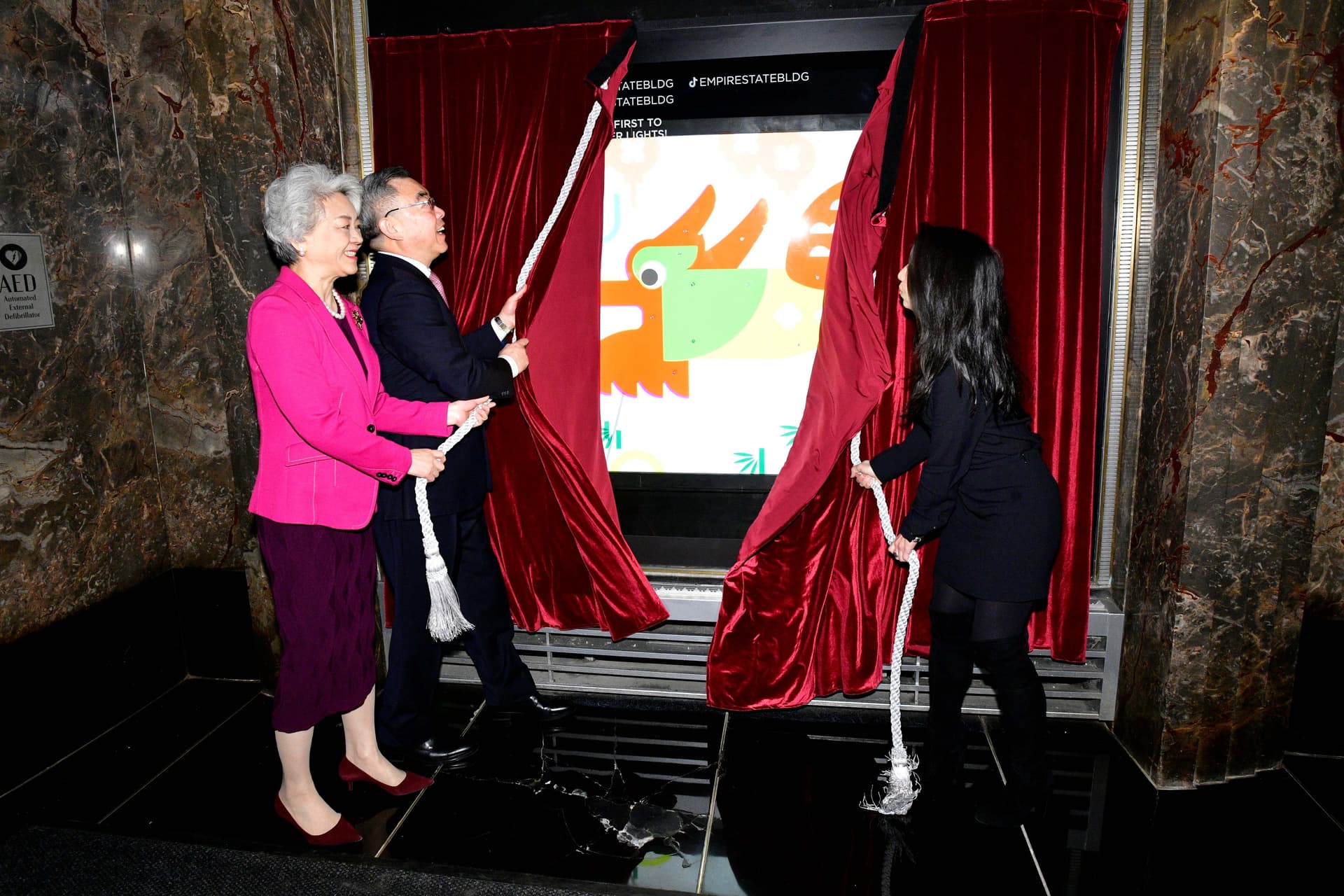 Counsel General Huang Ping, Madame Zhang Aiping, and ESRT EVP, COO & CFO Christina Chiu unveil the Lunar New Year windows at ESB.