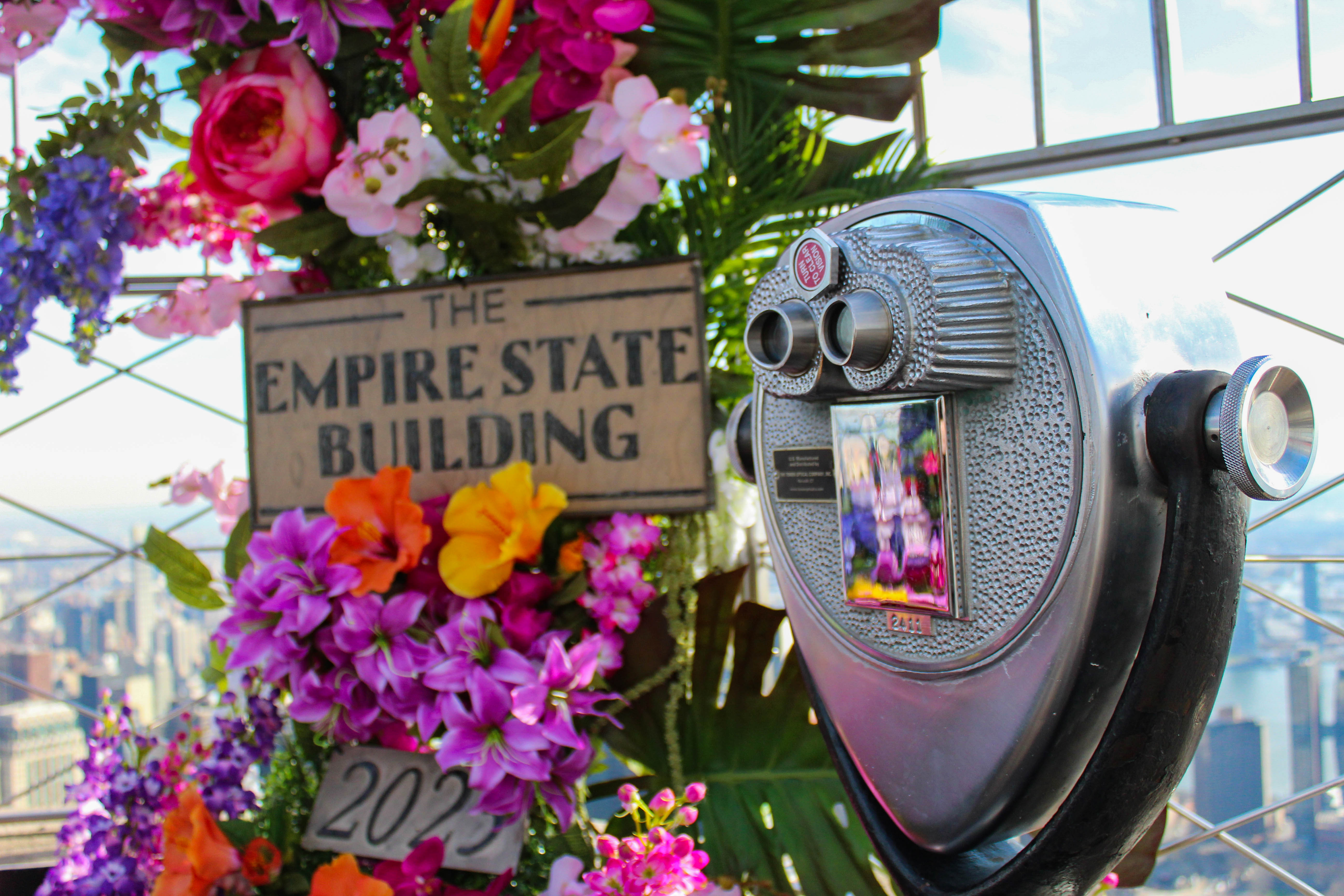 La parte superior del Empire State Building cubierta de flores.