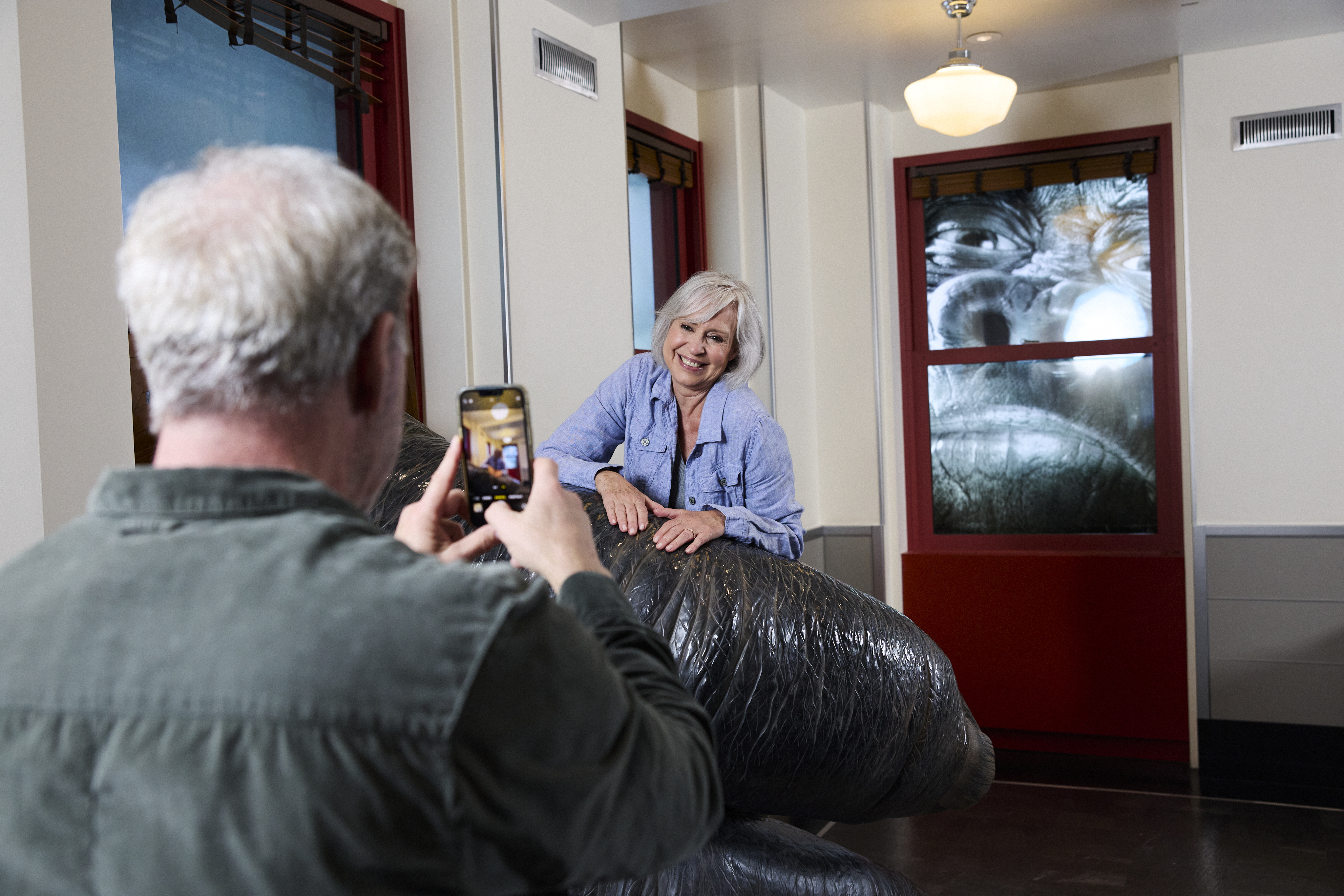 Husband takes photo of wife at the Empire State Building's King Kong exhibit