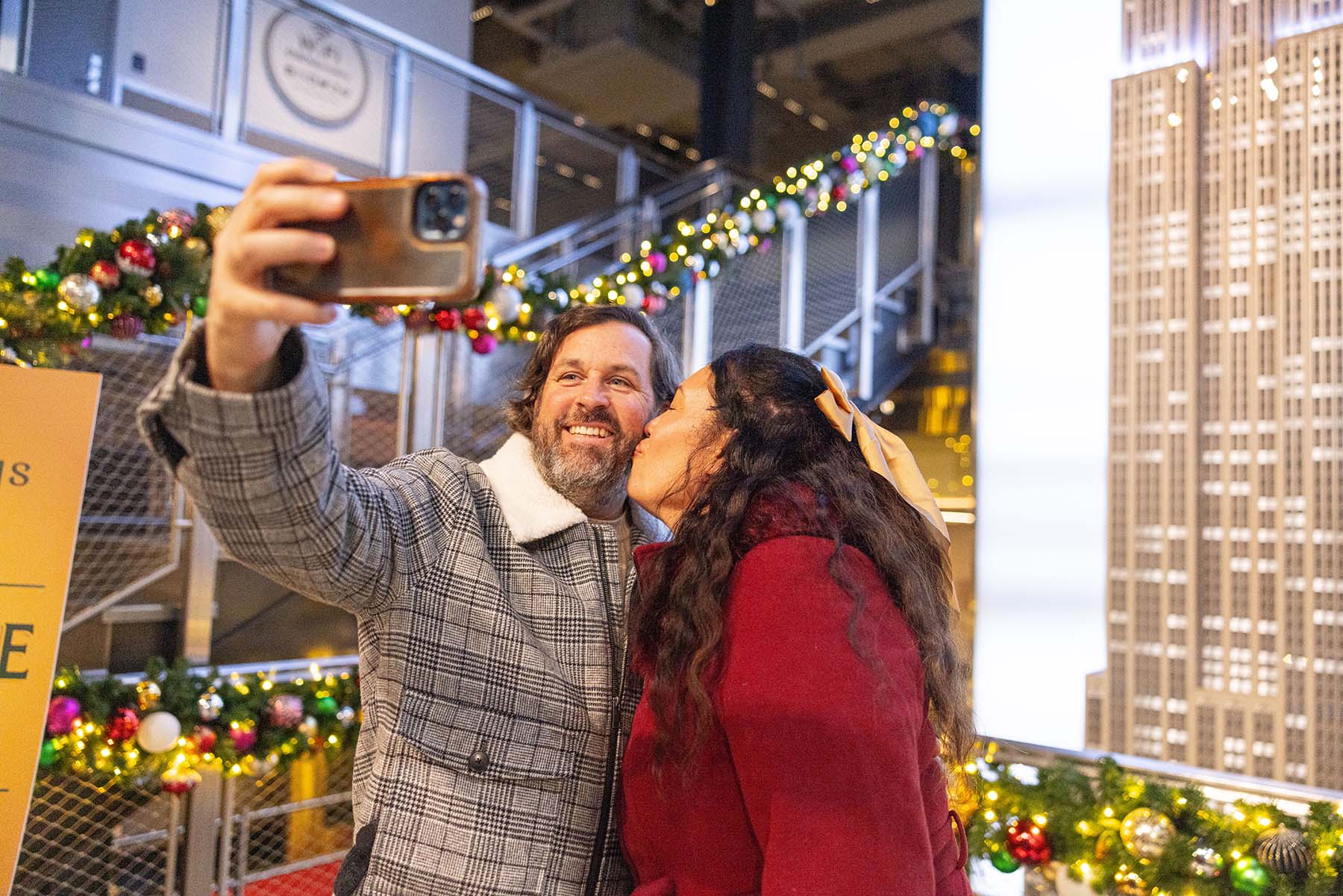The Empire State Building holiday decor grand staircase with couple taking selfie