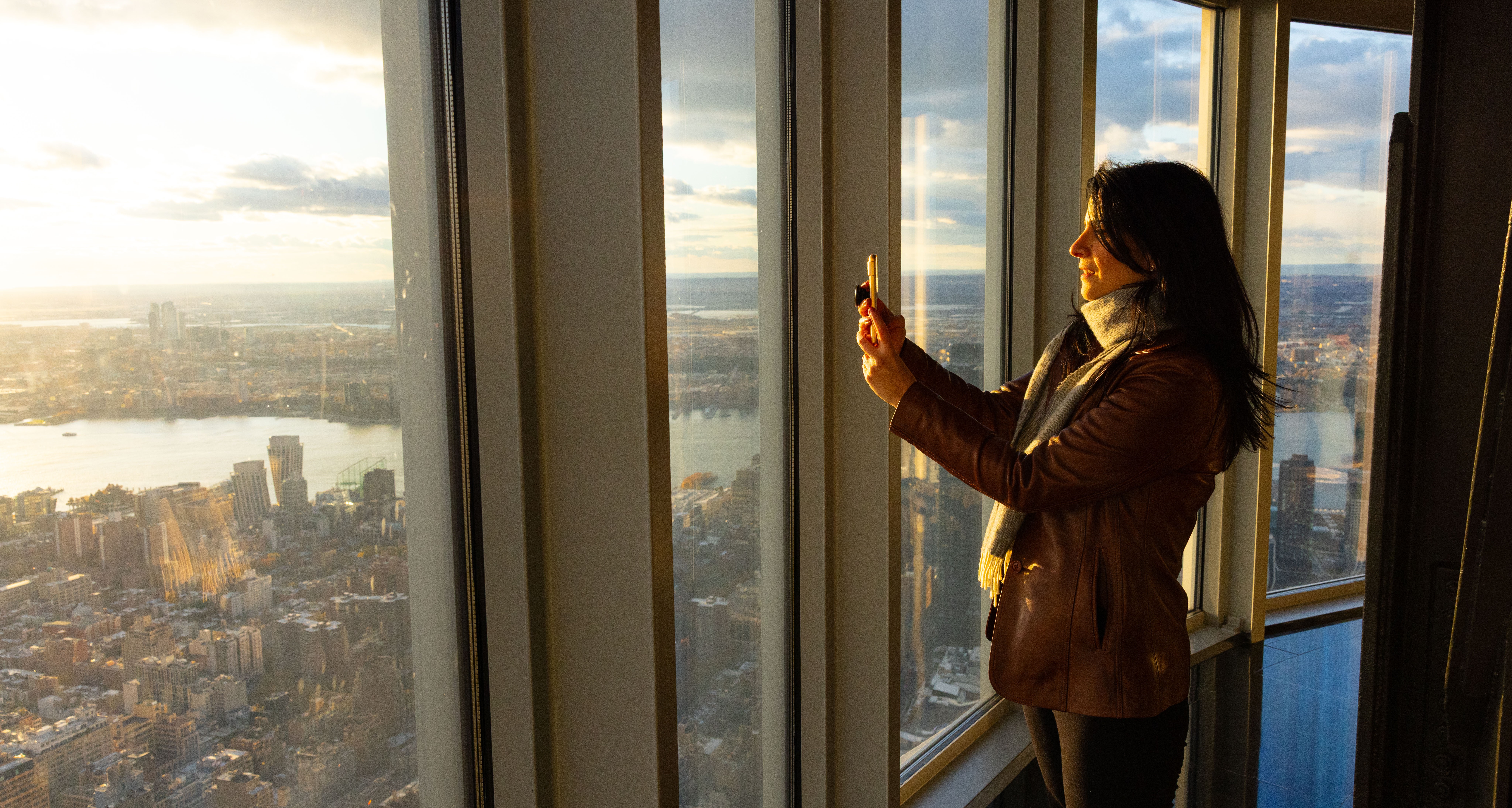 Woman taking a photo of the view from the 102nd Floor of the Empire State Building Observatory