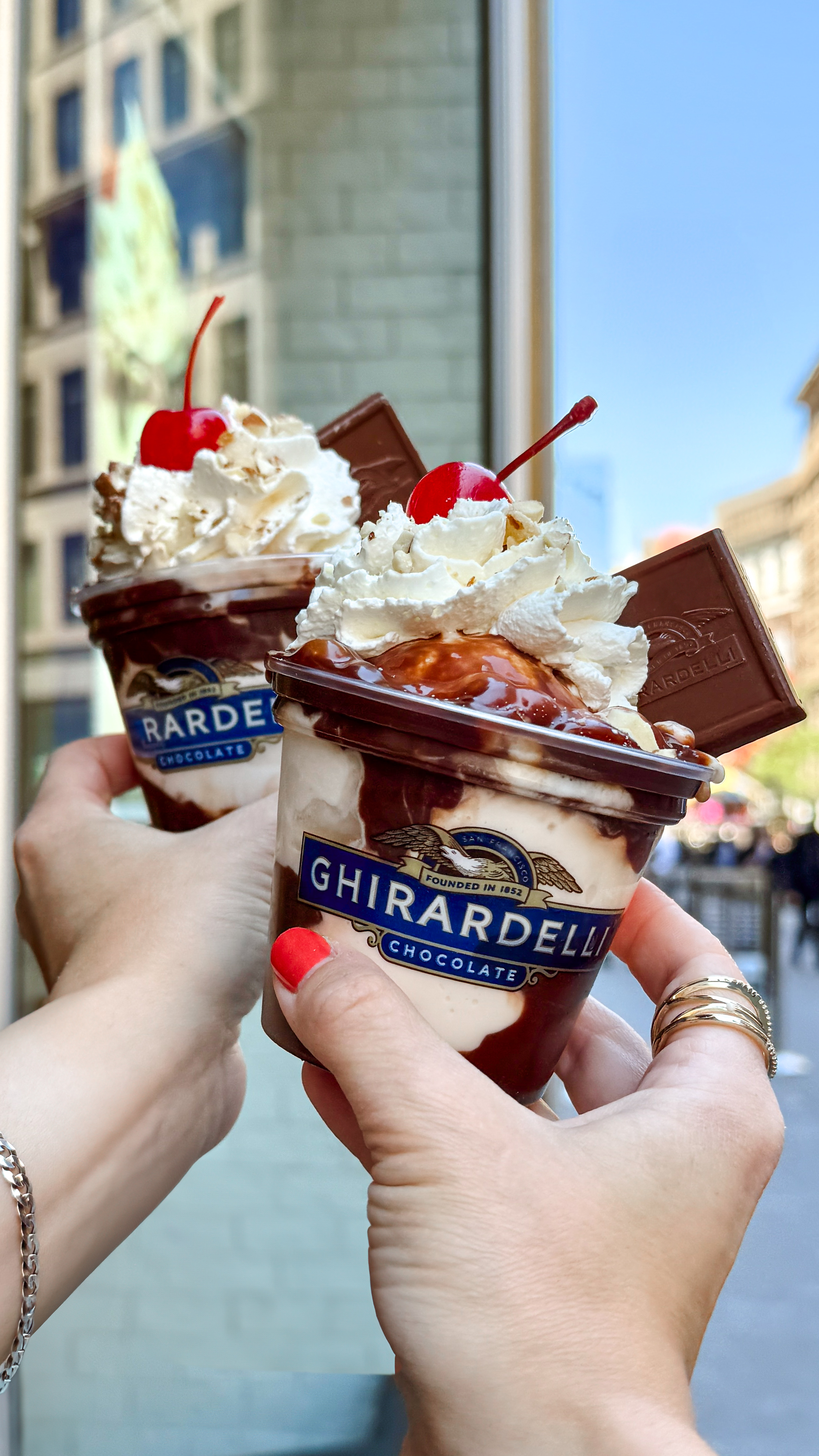 Two friends with Ghirardelli sundaes from the Ghirardelli Chocolate Company storefront at the Empire State Building Observation Deck