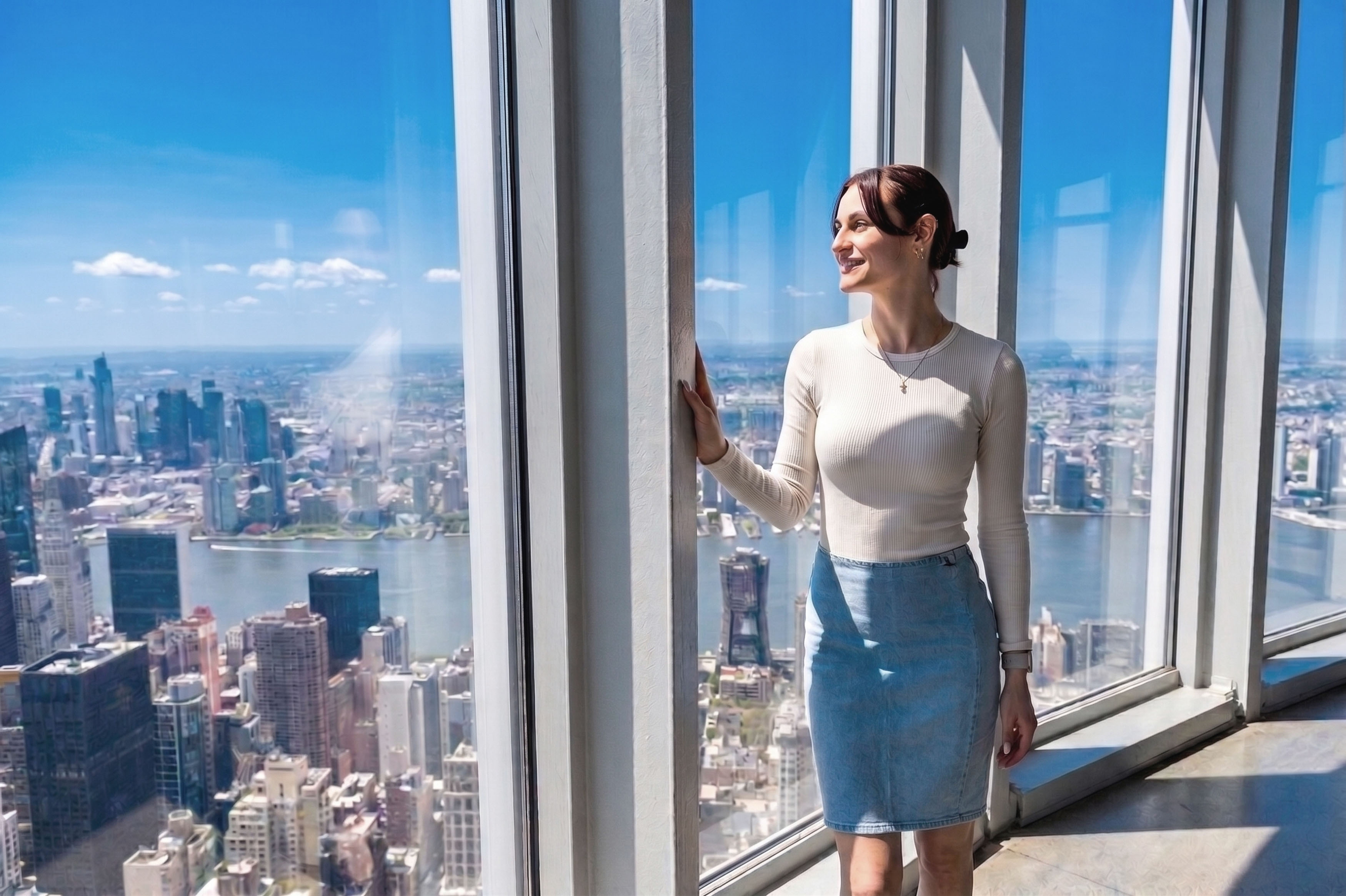 Girl looking through the floor-to-ceiling windows on the Empire State Building's 102nd Floor Observation Deck