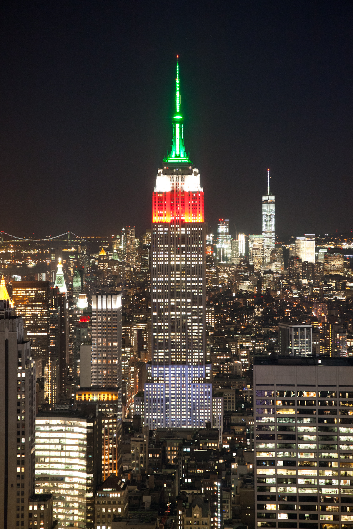 Light tower. Empire state building at top. empire state building wales colors. lighting tower. flag on top of the building.