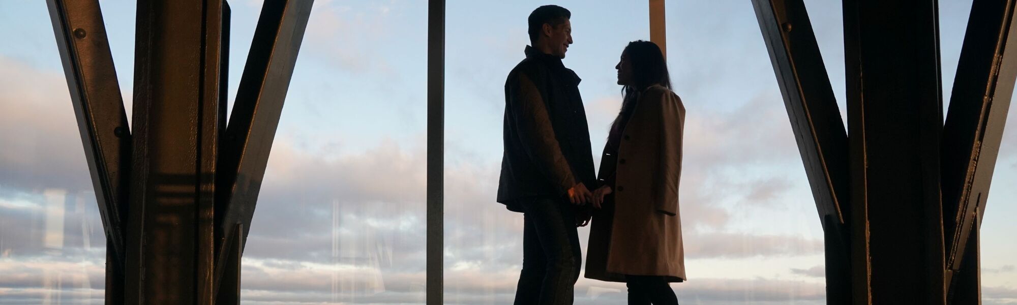 People looking out at NYC from the 102nd floor observation deck at the Empire State Building Observatory.