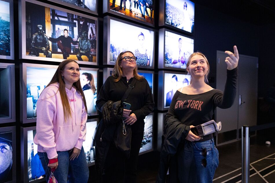 People observing the Worlds Most Famous Building 72-screen, 180-degree surround-sound theater exhibit on the 2nd floor of the Empire State Building Observatry experience.  