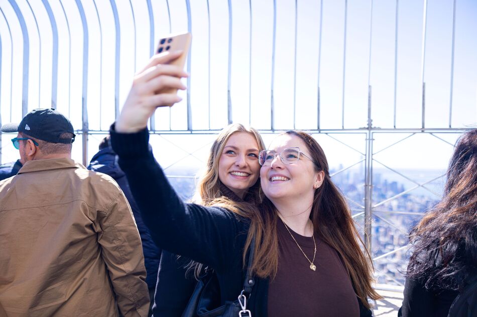 People taking a selfie with the view on the 86th Floor at the Empire State Building Observatry
