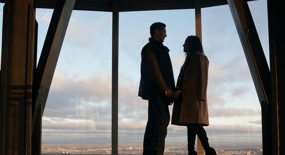 People looking out at NYC from the 102nd floor observation deck at the Empire State Building Observatory.
