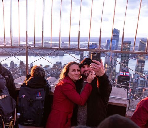 Guests taking a selfie on the 86th Floor Observation Deck at the Empire State Building Observatory.