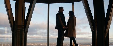 People looking out at NYC from the 102nd floor observation deck at the Empire State Building Observatory.