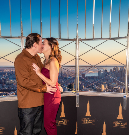 Casal se beijando em área reservada no topo do Empire State Building ao pôr do sol