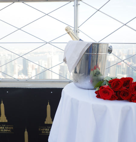 Des roses et une bouteille de champagne dans un seau à glace sur une table au sommet de l'Empire State Building