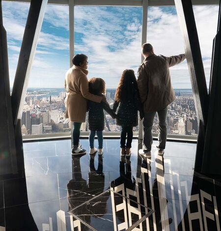 Family on the 102nd floor at the Empire State Building Observatory overlooking view.