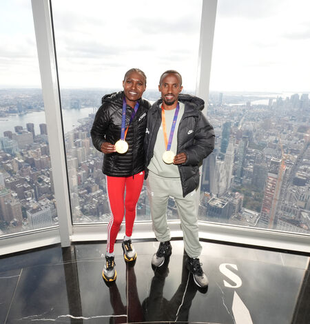 New York City Marathon Winners posing for a photo on the 102nd floor observation deck at the Empire State Building Observatory. 