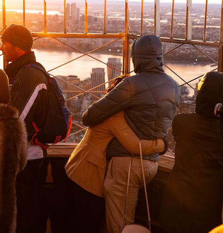 People looking at the sunset view from the 86th Floor Observation Deck at the Empire State Building Observatory