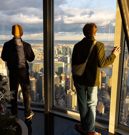 Two people looking out ESB's 102nd Floor NYC Observatory