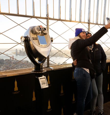 People taking a selfie with the view on the 86th Floor at the Empire State Building Observatry
