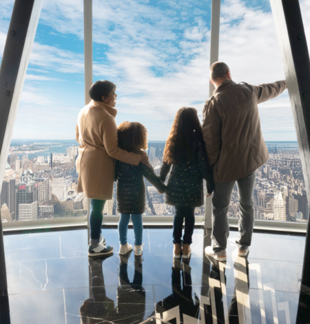 People observing the view from the 102nd floor observation deck at the Empire State Building Observatory experience. 