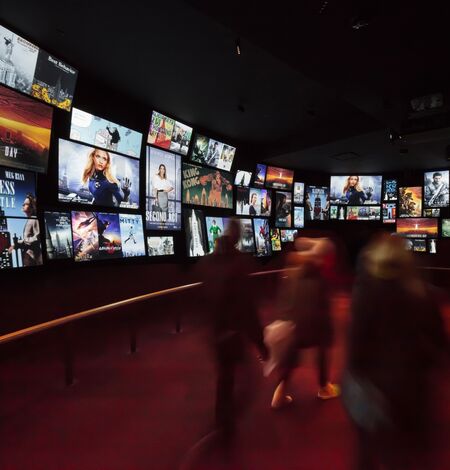 People observing the Worlds Most Famous Building 72-screen, 180-degree surround-sound theater exhibit on the 2nd floor of the Empire State Building Observatry experience.  