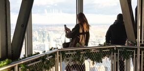 Woman taking photo on the Empire State Building 102nd Floor Observatory with holiday decorations