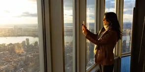 Woman taking a photo of the view from the 102nd Floor of the Empire State Building Observatory
