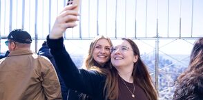 People taking a selfie with the view on the 86th Floor at the Empire State Building Observatry