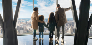 People observing the view from the 102nd floor observation deck at the Empire State Building Observatory experience. 