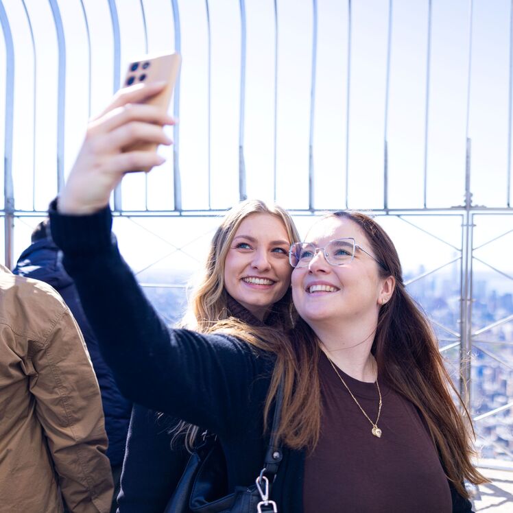 People taking a selfie with the view on the 86th Floor at the Empire State Building Observatry