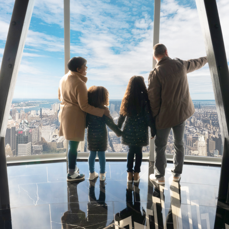 People observing the view from the 102nd floor observation deck at the Empire State Building Observatory experience. 