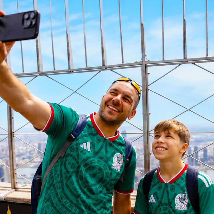 Father and son with football jerseys taking selfie