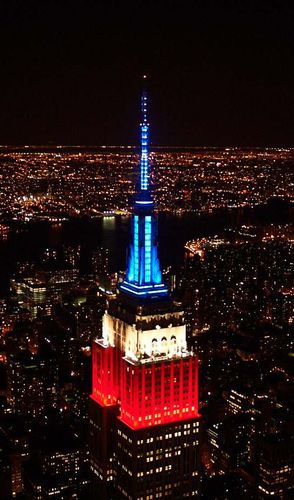 Rot-weißer und blauer Turm beleuchtet das Empire State Building